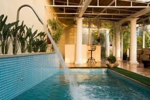 una piscina con una fuente en un edificio en Hotel Solar do Império, en Petrópolis