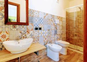 a bathroom with a sink and a toilet and a mirror at La quercia di Massena in Lauria Inferiore