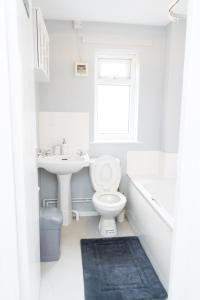 a white bathroom with a toilet and a sink at Vanville Homes in Manchester