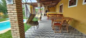 a patio with a table and chairs and a pool at Gold Star Village Kitnet equipado in Majorlândia