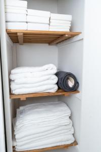 un armario lleno de toallas blancas en Vanville Homes en Mánchester
