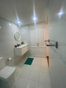 a white bathroom with a toilet and a sink at Espectacular Apartamento En Tanama Cap Cana in Punta Cana