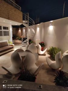 un grupo de sillas blancas en un patio por la noche en Una casa con vistas en Caracas, en Caracas