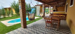 a patio with a table and chairs and a pool at Gold Star Village Kitnet equipado in Majorlândia