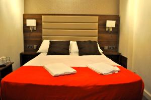 a bedroom with a large bed with two towels on it at Goodwood Hotel in London