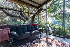 sala de estar con sofá frente a un árbol en The Sanctuary, en Captain Cook