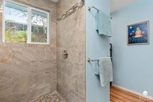 a bathroom with a shower with a glass door at The Sanctuary in Captain Cook
