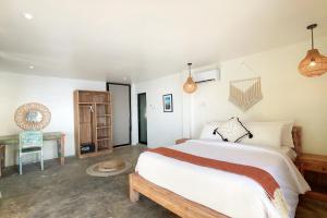 a bedroom with a large bed and a table at Impossible Cliff House in Uluwatu