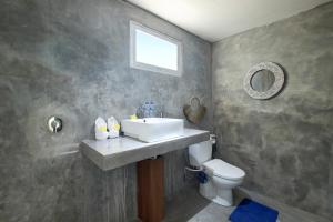 ein Bad mit einem Waschbecken und einem WC in der Unterkunft Impossible Cliff House in Uluwatu