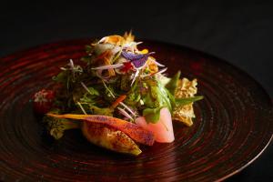 um prato vermelho de comida com uma salada em BYAKU Narai em Shiojiri