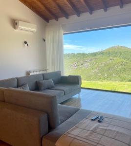 a living room with a couch and a large window at Casa do Afonso in Brufe