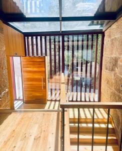 einen Balkon mit einer Holztür und einer Bank in der Unterkunft Casa do Afonso in Brufe