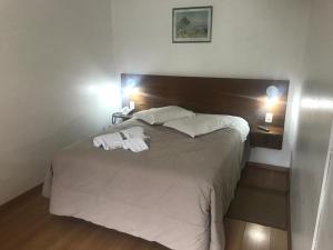 a bedroom with a bed with two towels on it at Apartamentos Aromas de Gramado - Bairro Centro in Gramado +171 photos