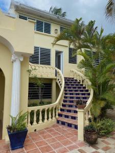 a house with a staircase in front of a building at Las Terrazas Los Chivos in Vieques