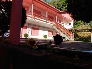 un edificio rojo y blanco con escaleras y flores en Apartamentos Aromas de Gramado - Bairro Centro en Gramado