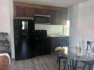 a kitchen with a black refrigerator and a table at Adobe Inn Durango in Durango