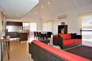 a living room with a red couch and a kitchen at Osprey Holiday Village Unit 104 in Exmouth