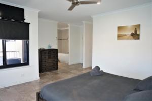 a bedroom with a bed and a window and a television at 27 Corella Court in Exmouth