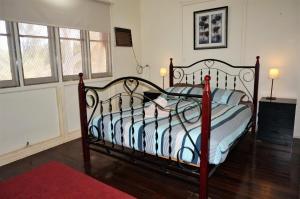 a bedroom with a bed with a black and white comforter at 10 Tautog Street in Exmouth