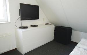 een kamer met een tv op een wit dressoir bij Porta Isola - Villa Water 105 in Stevensweert