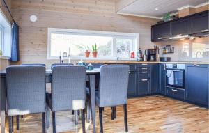 a kitchen with blue cabinets and a table with chairs at Beautiful Home In Skare With 3 Bedrooms in Lii