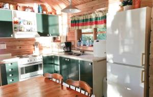 cocina con armarios verdes y nevera blanca en Cozy Home In Lilla Edet With Kitchen, en Lilla Edet