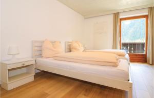 a white bedroom with a large bed with a window at 10 Bedroom Stunning Home In Sankt Sigmund in Sankt Sigmund im Sellrain