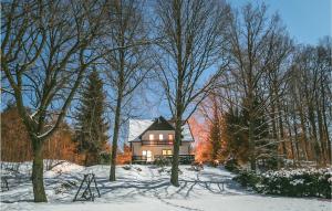 a house in the middle of a snow covered yard at Beautiful Home In Swietajno With 5 Bedrooms, Sauna And Wifi in Świętajno