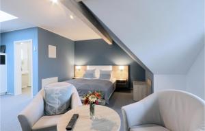 ダゲビュルにあるAmazing Apartment In Dagebll With Wifiのベッドルーム1室(ベッド1台、椅子2脚、テーブル付)