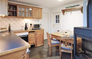 una cocina con armarios de madera y una mesa con sillas. en 2 Bedroom Amazing Apartment In Dagebll, en Dagebüll