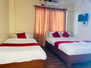 two beds sitting next to each other in a room at Hotel Dream Light in Pokhara