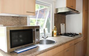 a kitchen with a sink and a microwave at 2 Bedroom Gorgeous Home In Rheezerveen in Rheezerveen