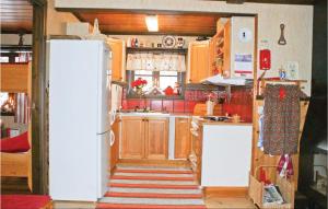 a kitchen with a white refrigerator and wooden cabinets at Awesome Home In Slen With 3 Bedrooms And Sauna in Lindvallen