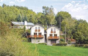 een groot wit huis op een heuvel met bomen bij Astrid in Burg-Reuland