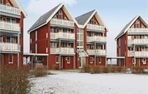 a red apartment building with white balconies on the beach at Amazing Apartment In Rechlin With Sauna in Rechlin
