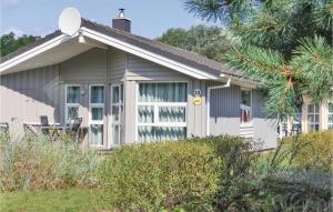 una pequeña casa blanca con satélite en Dnenpark 13 - Dorf 6, en Priwall