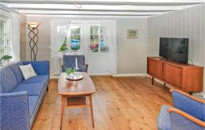 uma sala de estar com cadeiras azuis e uma televisão em Gorgeous Home In Dirdal With House A Mountain View em Dirdal