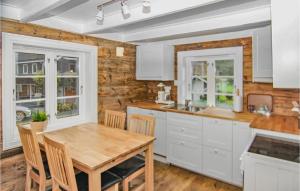 a kitchen with white cabinets and a wooden table at Gorgeous Home In Dirdal With House A Mountain View in Dirdal