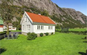 a small white house with an orange roof on a green yard at Gorgeous Home In Dirdal With House A Mountain View in Dirdal
