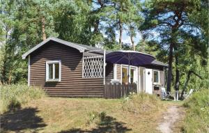 eine kleine Hütte mit einem Sonnenschirm davor in der Unterkunft 2 Bedroom Stunning Home In Lderup in Löderup