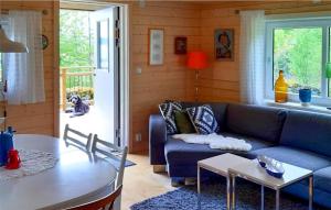 ベーナムーにあるAmazing home in Vrnamo with 3 Bedrooms and WiFiのリビングルーム(青いソファ、テーブル付)