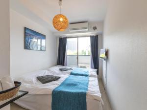 Tabist Gloire Osaka في أوساكا: غرفة نوم عليها سرير وبطانية زرقاء