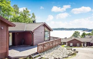 NedstrandにあるBeautiful Home In Nedstrand With 4 Bedrooms, Sauna And Wifiの家 背景に湖がある家