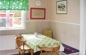ビンメルビューにあるNice Home In Vimmerby With Kitchenのダイニングルーム(テーブル、椅子、時計付)