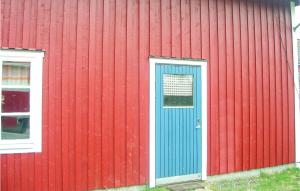 ビンメルビューにあるNice Home In Vimmerby With Kitchenの青い扉と窓のある赤い建物