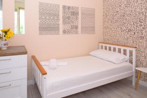 a small bedroom with a white bed and a desk at Lovely apartment Lungomare in Vlorë +9 photos