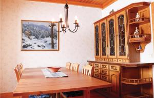 a dining room with a wooden table and a chandelier at Stunning Home In Agunnaryd With 4 Bedrooms And Wifi in Agunnaryd