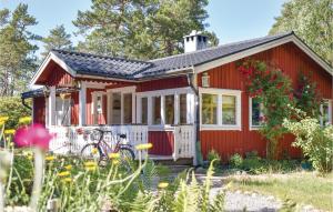 a red tiny house with a bike in the yard at Cozy Home In Djurhamn With Wifi in Djurhamn