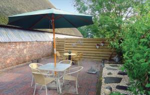 a table and chairs with an umbrella on a patio at 3 Bedroom Cozy Apartment In Paesens in Paesens
