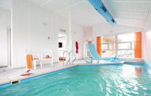 a pool with a slide and chairs in a room at Freibeuterweg 6 - Dorf 6 in Travemünde